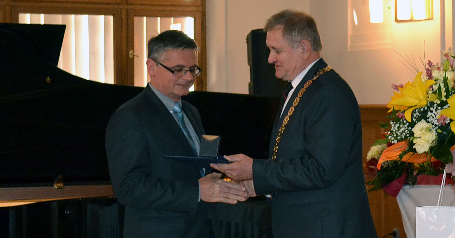 MUDr.Škodáček preberá cenu z rúk predsedu NSK