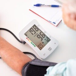 Old senior man using medical device to measure blood pressure –